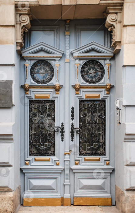 Скачать Богато украшенные синие двойные двери с декоративной металлической отделкой и звездчатыми мотивами фотосток Ozero