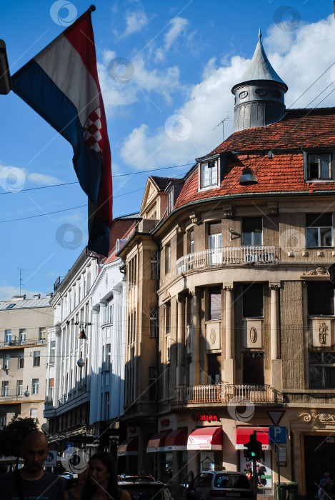 Скачать Уличная сцена в Загребе с историческими зданиями и хорватским флагом фотосток Ozero