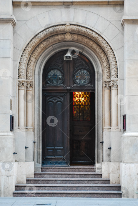 Скачать Элегантный арочный деревянный дверной проем с замысловатой каменной кладкой и витражным окном фотосток Ozero