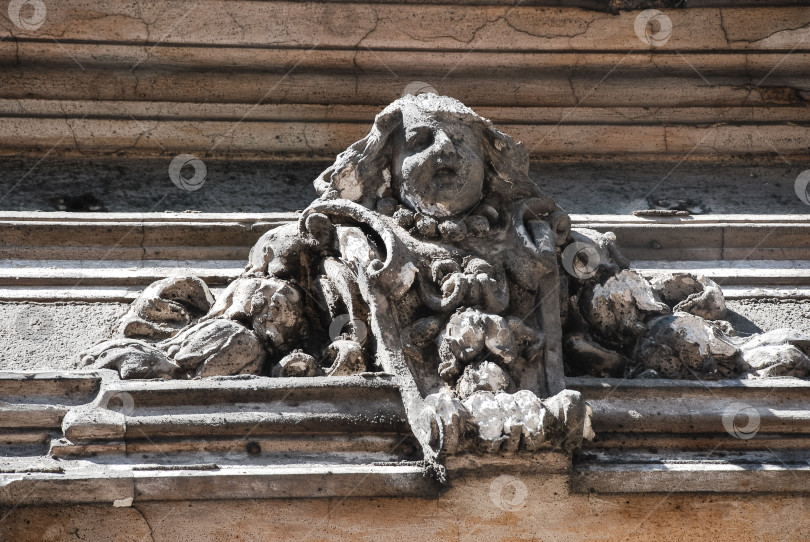 Скачать Каменная фигура ангела, украшающая фасад исторической архитектуры замысловатыми деталями фотосток Ozero
