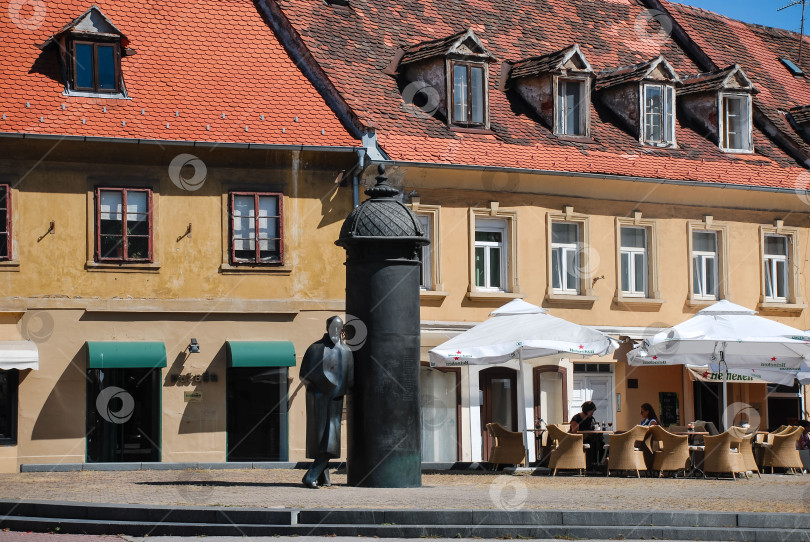 Скачать Уличное кафе и историческая статуя на европейской площади с традиционной архитектурой фотосток Ozero