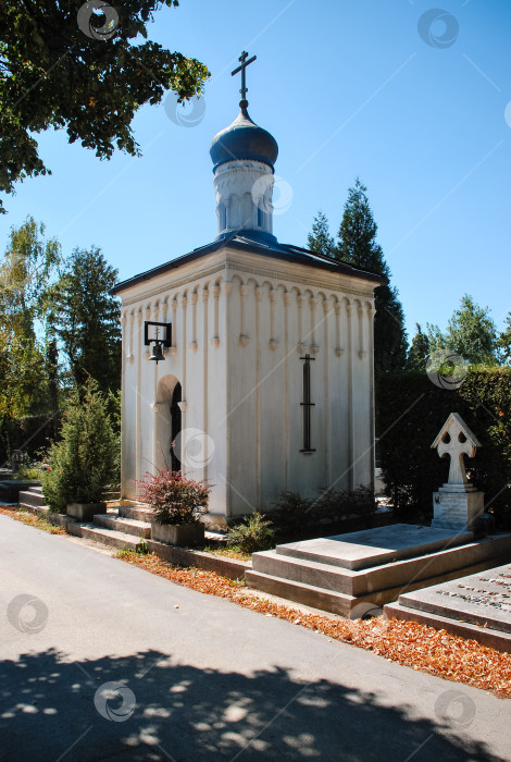 Скачать Белая православная часовня на тихом кладбище с голубым куполом под ясным небом фотосток Ozero