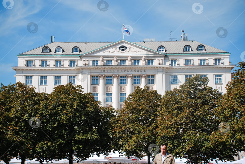 Скачать Величественное историческое здание отеля с деревьями и голубым небом фотосток Ozero