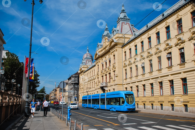 Скачать Синий трамвай на исторической улице Загреба в солнечный день фотосток Ozero