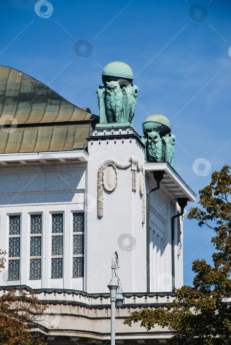 Скачать Богато украшенные скульптуры на крыше исторического здания под ясным голубым небом фотосток Ozero