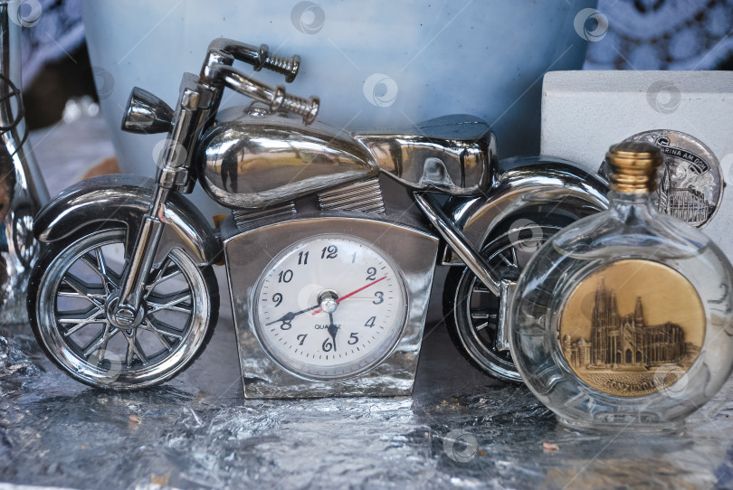 Скачать Старинные серебряные мотоциклетные часы с декоративной бутылкой виски и богато украшенной монетой фотосток Ozero