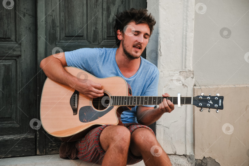 Скачать Молодой кавказец играет на акустической гитаре на улице фотосток Ozero