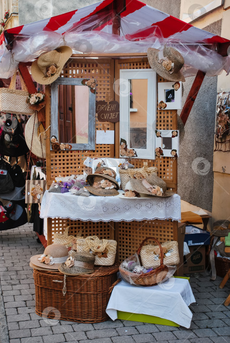 Скачать Выставка соломенных шляп и аксессуаров на стенде уличного рынка фотосток Ozero
