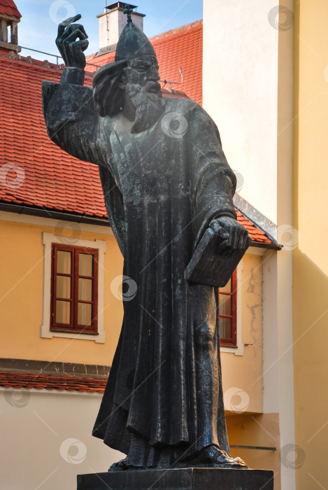 Скачать Древний каменный памятник, изображающий историческую личность с книгой в руках фотосток Ozero