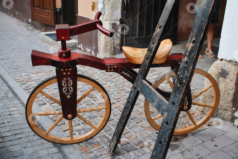 Скачать Старинный деревянный велосипед с декоративными деталями на мощеной улице фотосток Ozero