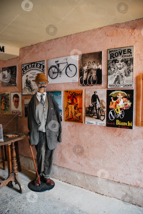Скачать Демонстрация старинных велосипедных плакатов с манекеном в исторической обстановке фотосток Ozero