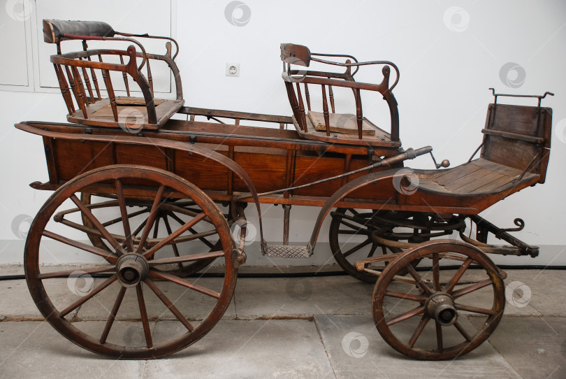 Скачать Старинная деревянная конная повозка с железными колесами в музейной обстановке фотосток Ozero
