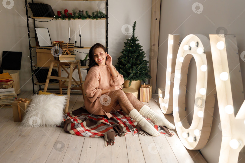 Скачать улыбающаяся женщина в платье в комнате, украшенной к Рождеству фотосток Ozero