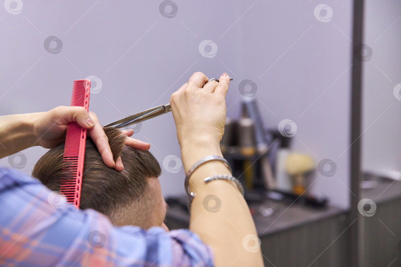 Скачать парикмахер, подстригающий волосы ножницами. Услуга стрижки фотосток Ozero