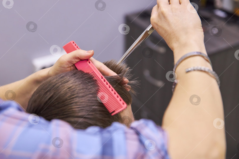 Скачать парикмахер, подстригающий волосы ножницами. Услуга стрижки фотосток Ozero