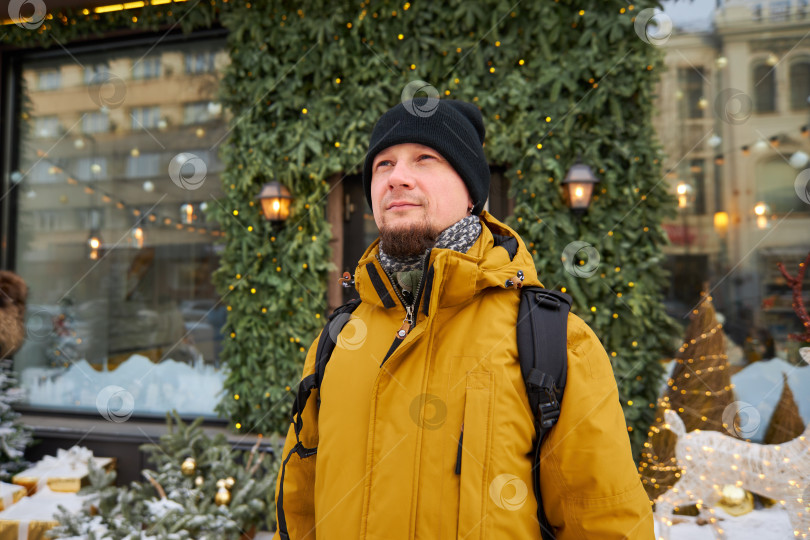 Скачать мужчина стоит на фоне витрин магазинов, украшенных к Рождеству фотосток Ozero