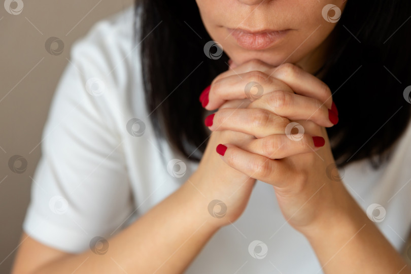 Скачать женщина положила подбородок на скрещенные пальцы и молится фотосток Ozero