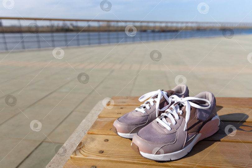 Скачать кроссовки стоят на деревянных досках на фоне брусчатки фотосток Ozero