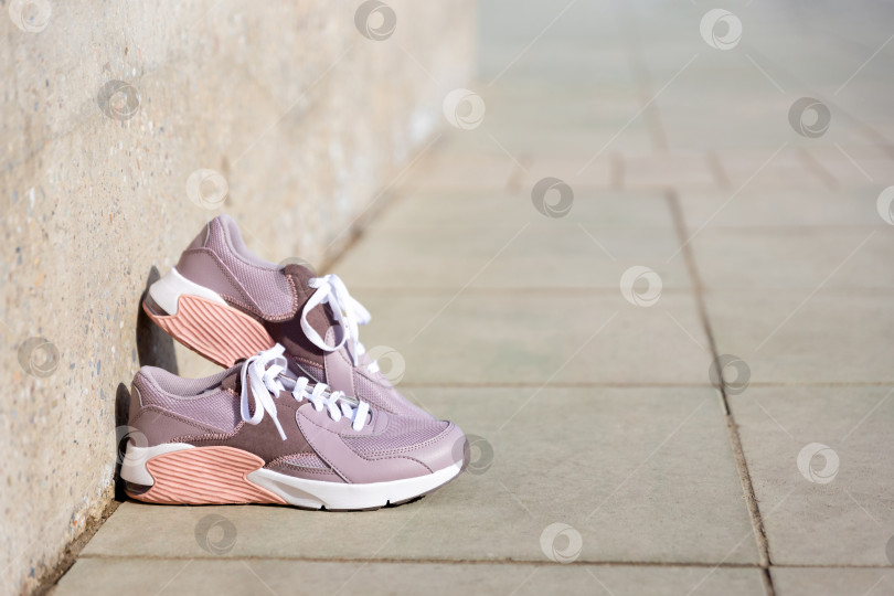Скачать кроссовки стоят на брусчатке. Место для текста фотосток Ozero