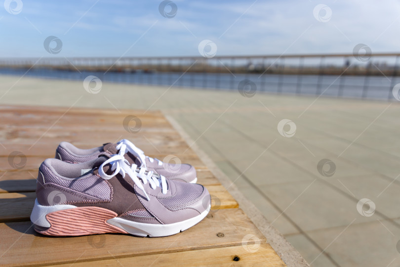 Скачать кроссовки стоят на деревянных досках на фоне брусчатки фотосток Ozero