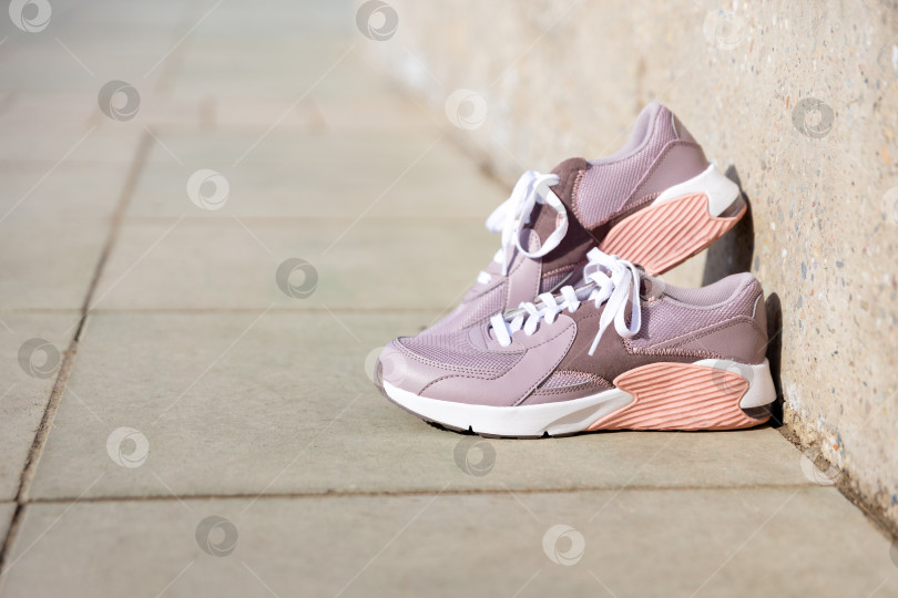 Скачать кроссовки стоят на брусчатке. Место для текста фотосток Ozero