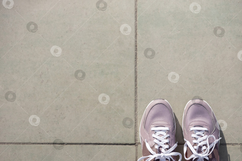 Скачать кроссовки стоят на брусчатке. Место для текста фотосток Ozero