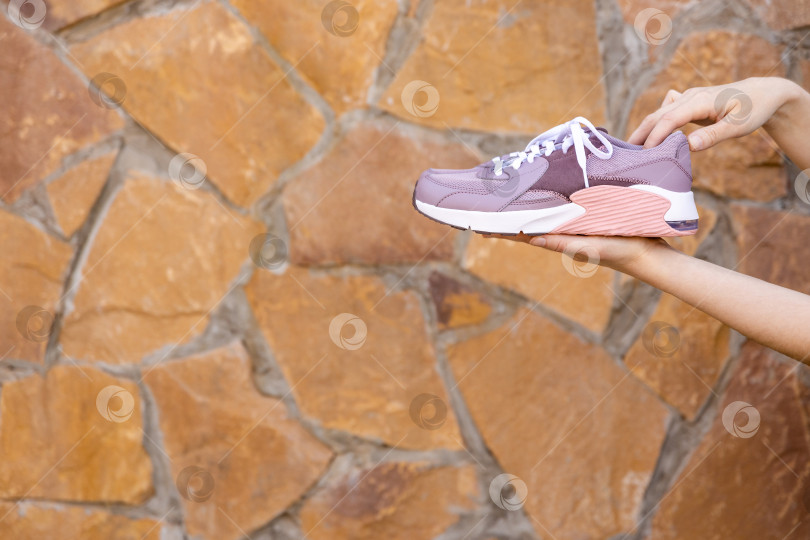 Скачать женщина держит в руках кроссовки. Место для текста фотосток Ozero