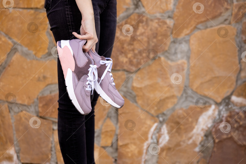 Скачать женщина держит в руках кроссовки. Место для текста фотосток Ozero