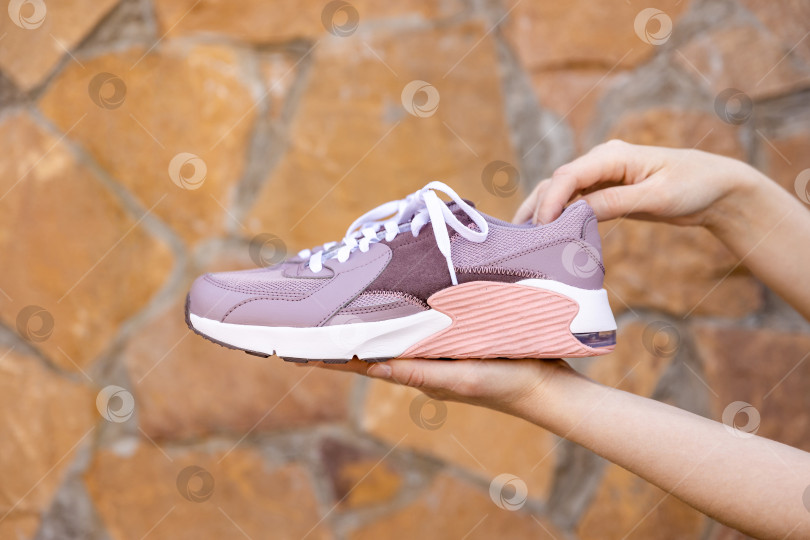 Скачать женщина держит в руках кроссовки. Место для текста фотосток Ozero