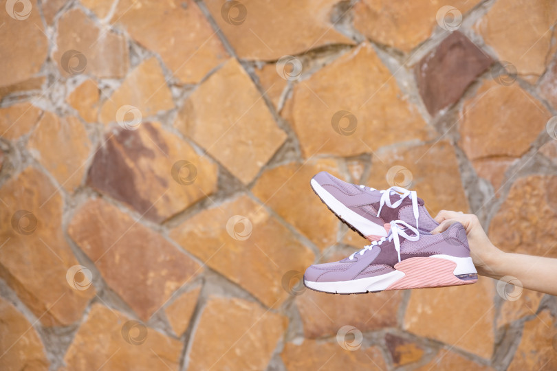 Скачать женщина держит в руках кроссовки. Место для текста фотосток Ozero