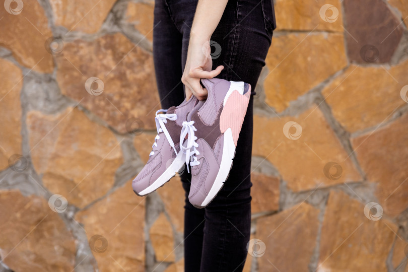 Скачать женщина держит в руках кроссовки. Место для текста фотосток Ozero