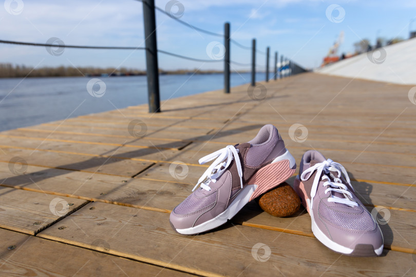 Скачать пара кроссовок на деревянном пирсе на набережной фотосток Ozero