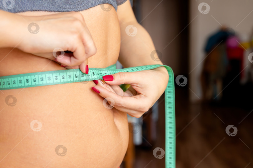 Скачать женщина измеряет живот с помощью рулетки фотосток Ozero