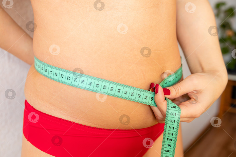 Скачать женщина измеряет живот с помощью рулетки фотосток Ozero