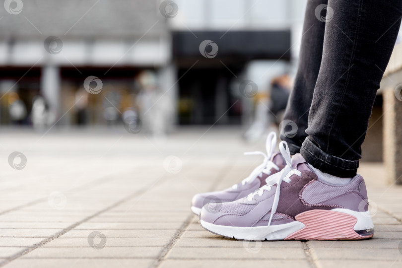 Скачать женщина в черных джинсах и кроссовках сидит на скамейке фотосток Ozero