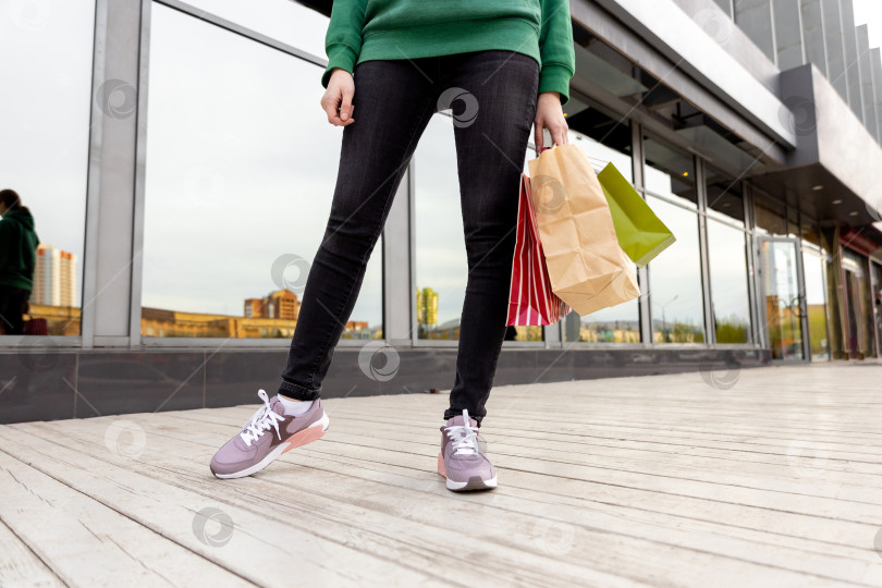 Скачать женщина в джинсах и кроссовках, с сумками для покупок фотосток Ozero