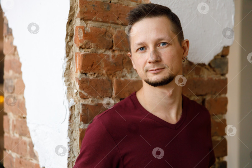 Скачать портрет бородатого брюнета крупным планом в футболке на фоне кирпичной стены фотосток Ozero