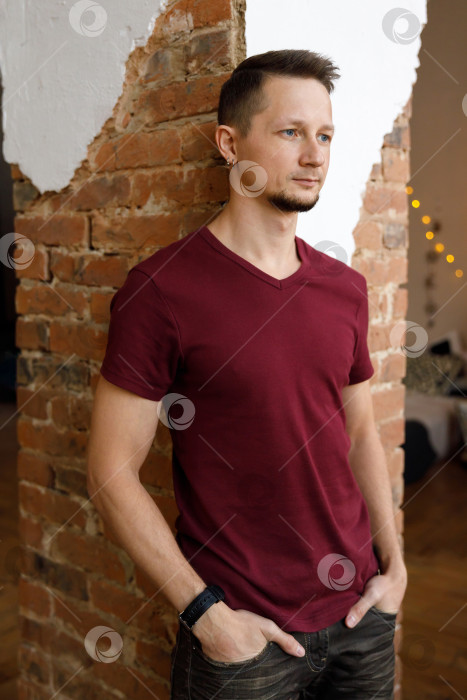 Скачать портрет бородатого брюнета крупным планом в футболке на фоне кирпичной стены фотосток Ozero