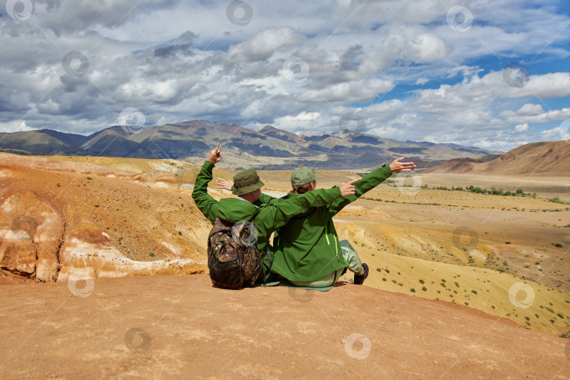 Скачать пара туристов сидят на фоне пейзажа летним днем фотосток Ozero