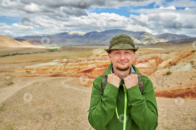 Скачать портрет мужчины-туриста стоит на фоне пейзажа фотосток Ozero