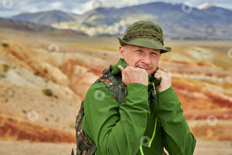 Скачать портрет мужчины-туриста стоит на фоне пейзажа фотосток Ozero