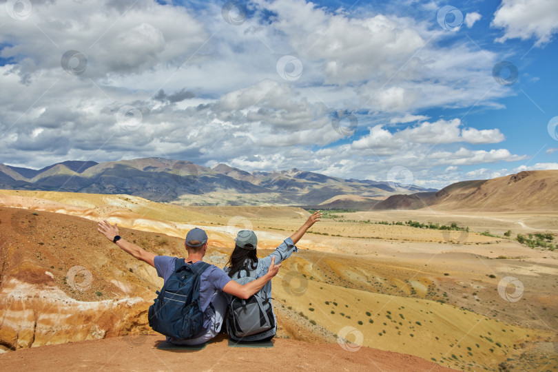 Скачать пара туристов сидит спиной к камере на фоне пейзажа фотосток Ozero