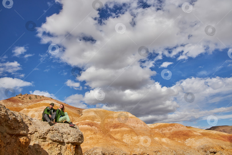Скачать женщина и мужчина-туристы в мембранной куртке сидят в песчаном карьере фотосток Ozero