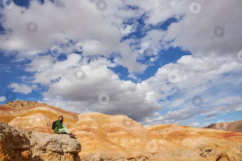 Скачать туристка в мембранной куртке сидит в песчаном карьере фотосток Ozero