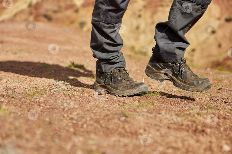 Скачать мужские ноги в походных ботинках взбираются на песчаный холм фотосток Ozero
