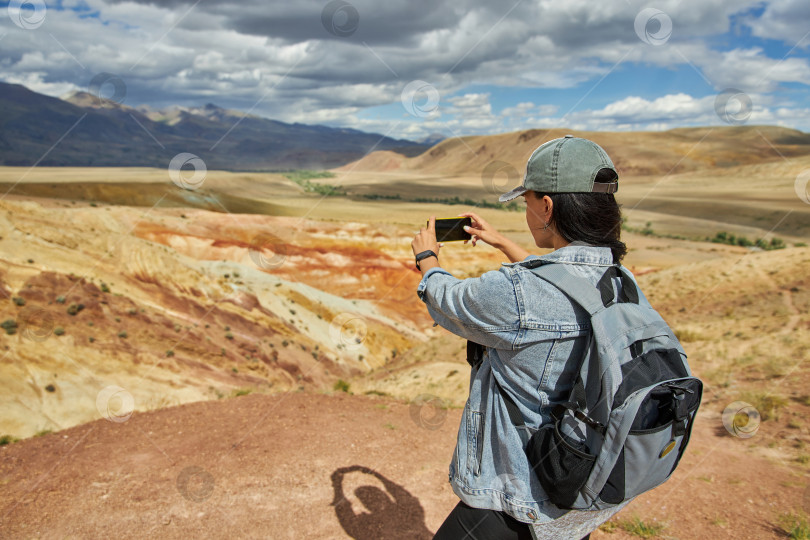 Скачать женщина-туристка фотографирует горный и пустынный пейзаж фотосток Ozero