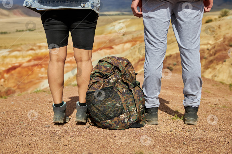 Скачать ноги женщины и мужчины-туристов в походных ботинках и с рюкзаком фотосток Ozero