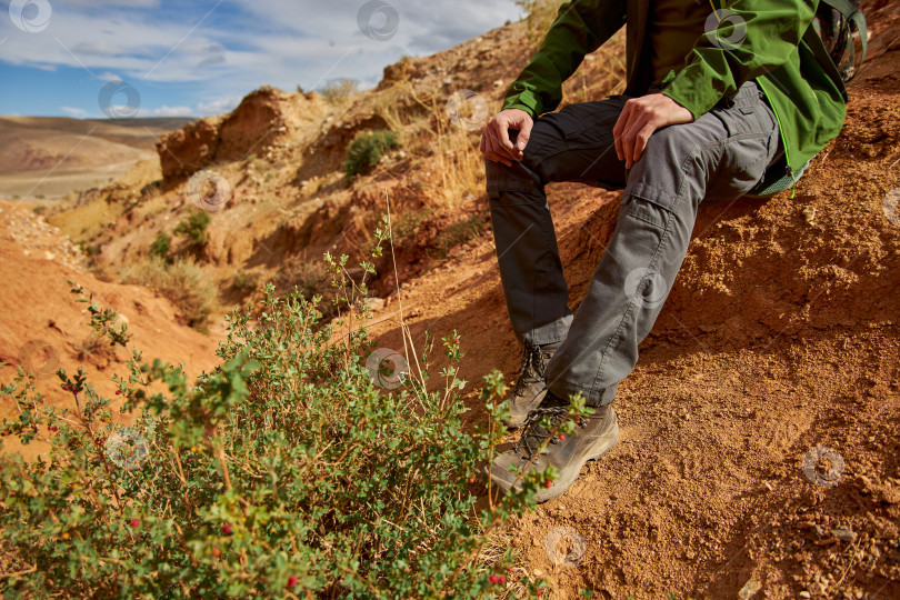 Скачать мужчина-турист в мембранной куртке, тактических брюках и походных ботинках фотосток Ozero