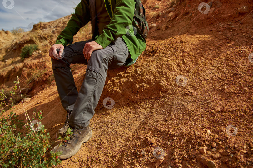 Скачать мужчина-турист в мембранной куртке, тактических брюках и походных ботинках фотосток Ozero