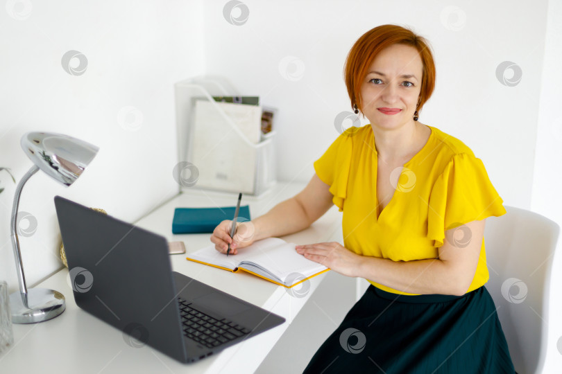 Скачать женщина в желтой блузке работает за ноутбуком фотосток Ozero
